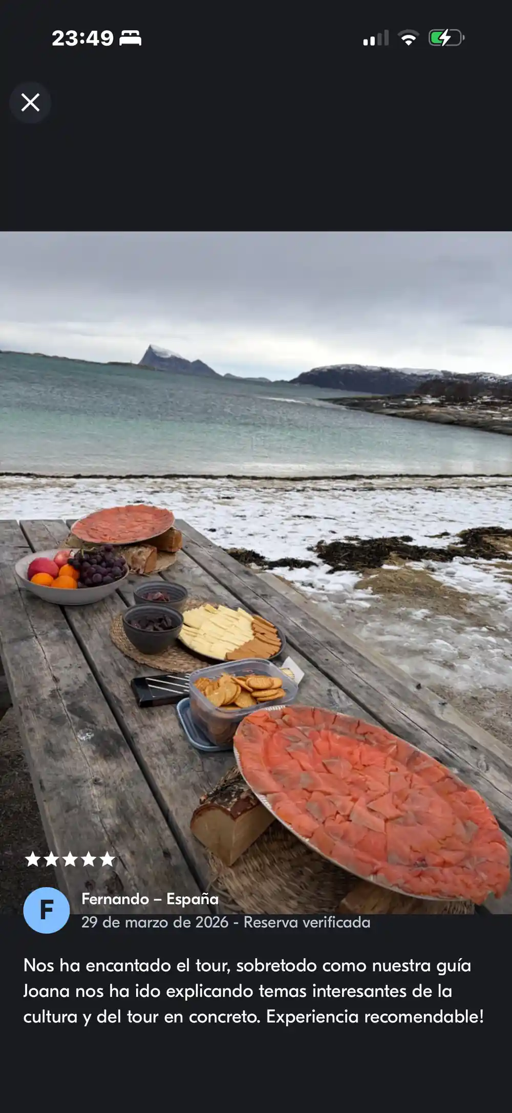 A laid picnic table on a snowy shore with mountains behind